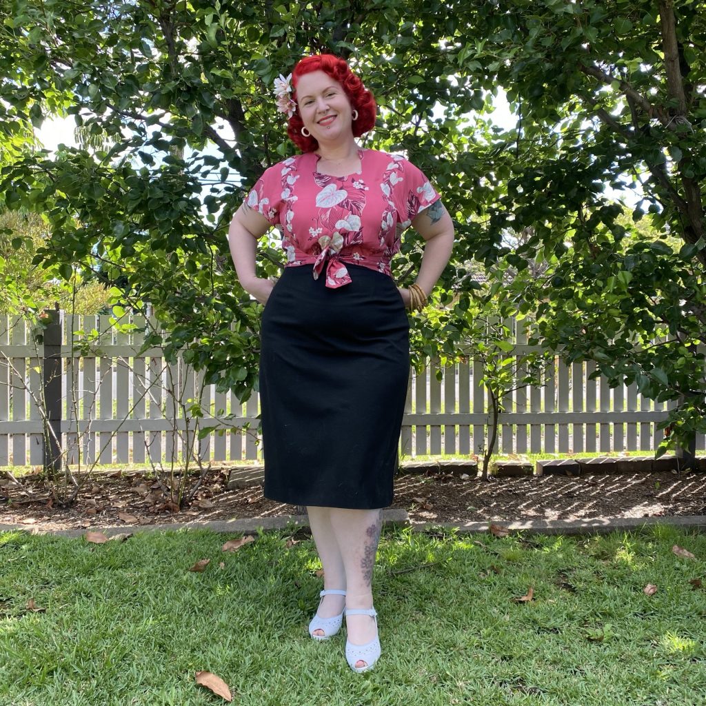Photo of a red haired woman wearing a pink blouse